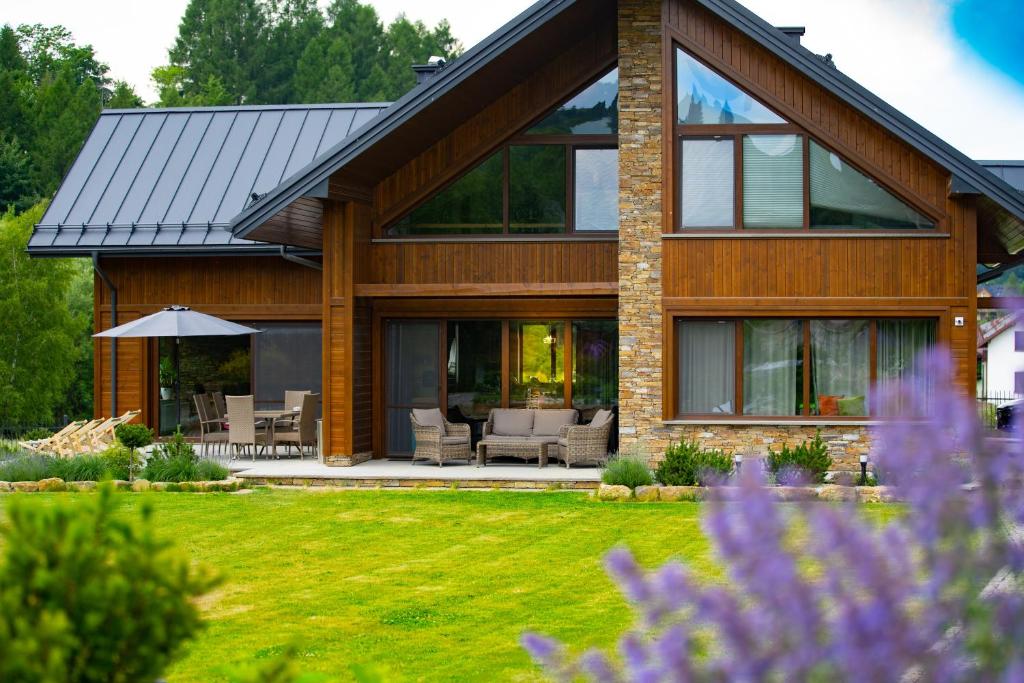 una casa con ventanas de cristal y un patio en Willa Mariza Szczawnica Jaworki, en Szczawnica