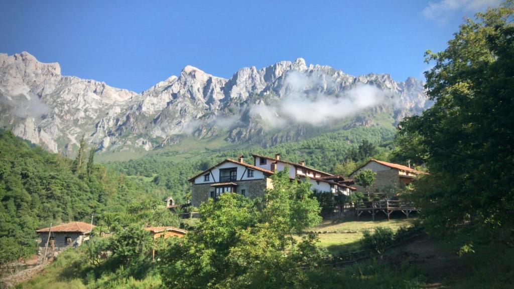una casa en una colina frente a una montaña en Posada Las Espedillas, en Camaleño