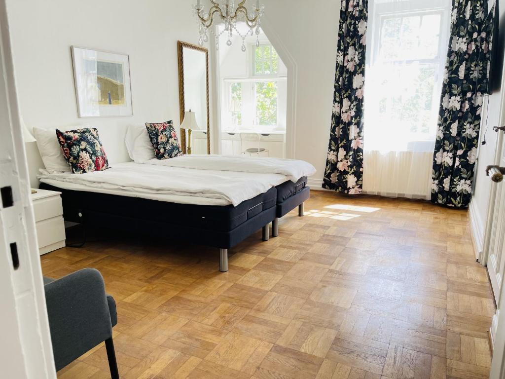 a bedroom with a bed and a wooden floor at aday - Aalborg Mansion - 3 bedroom apartment in Aalborg