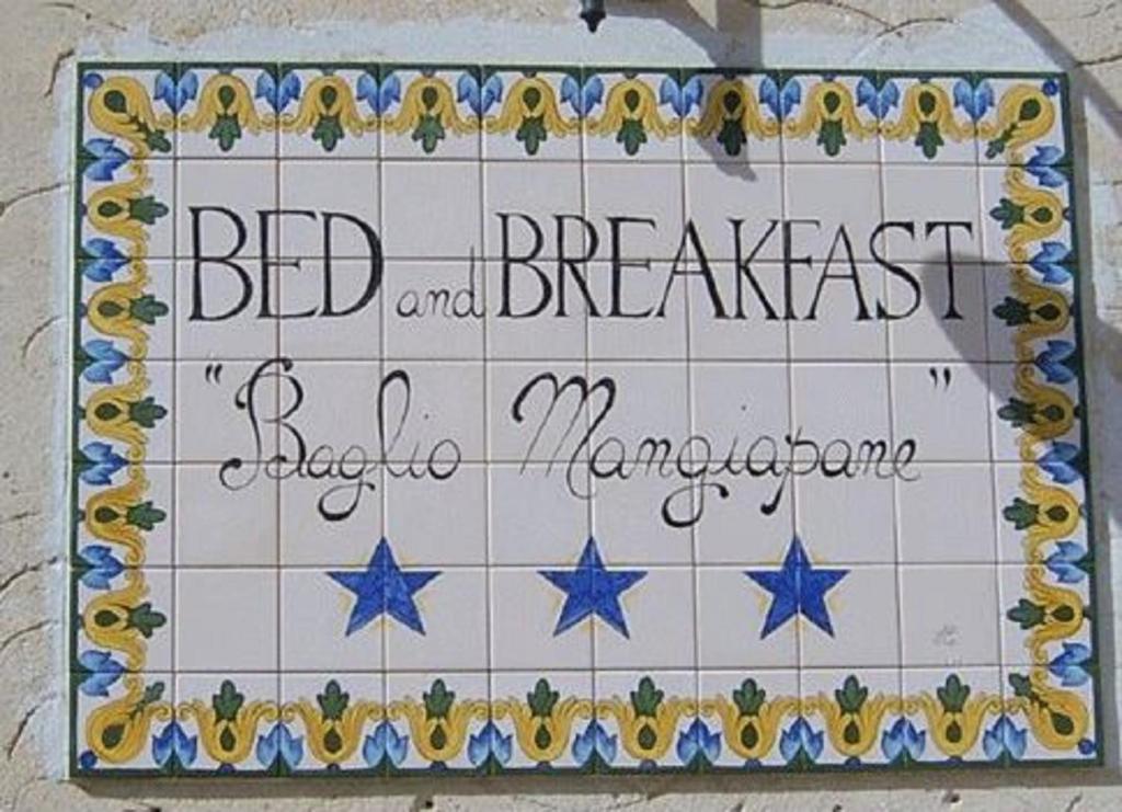 um sinal para um alojamento de acomodação e pequeno-almoço numa parede de azulejos em B & B Baglio Mangiapane em Custonaci