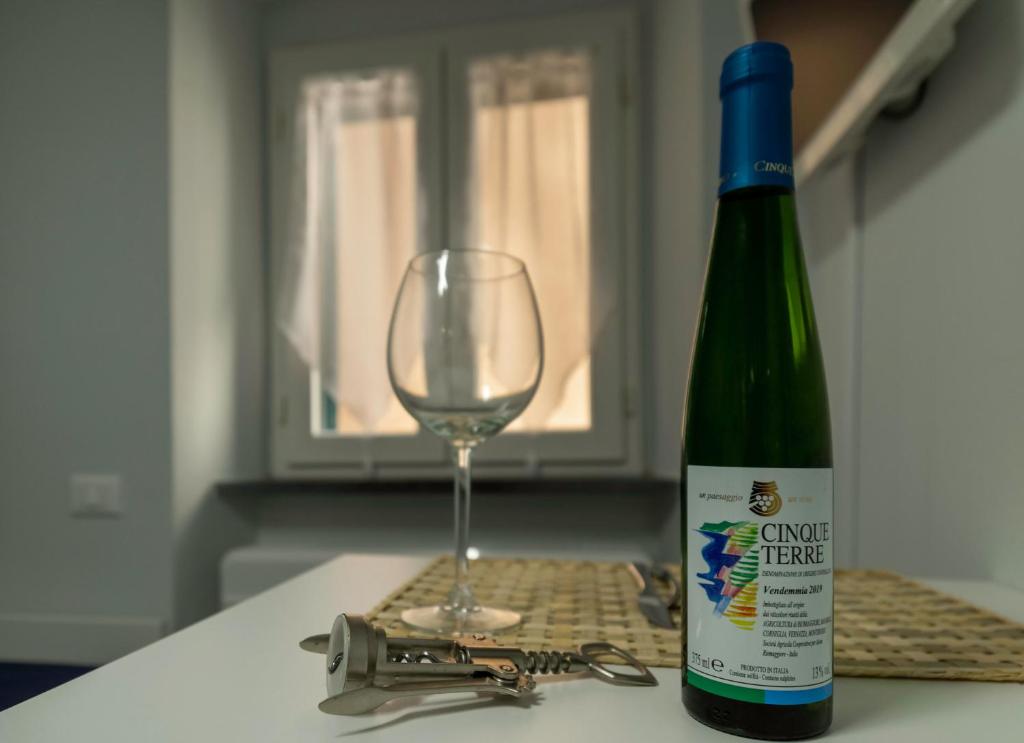 a bottle of wine sitting next to a wine glass at Affittacamere Le Pescatrici in Riomaggiore