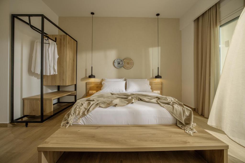 a bedroom with a large bed with a wooden table at Casa Costa Suites in Kanali