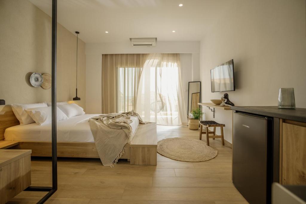 a bedroom with a bed and a table in a room at Casa Costa Suites in Kanali
