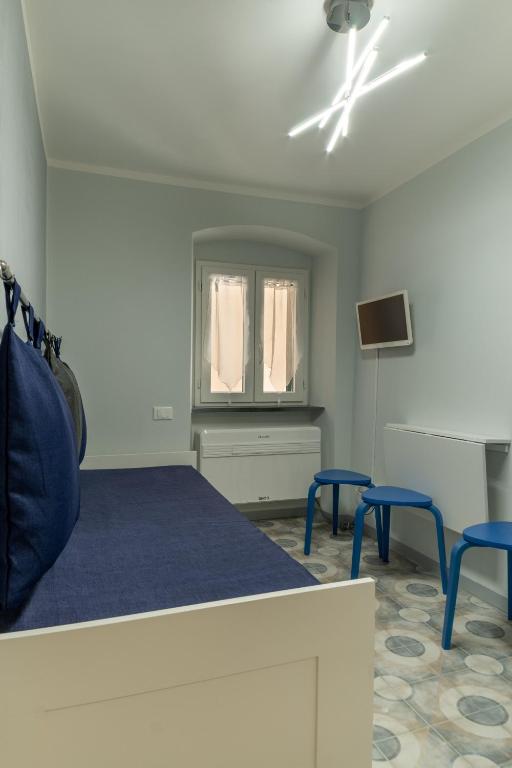 a bedroom with a bed and two blue stools at Affittacamere Le Pescatrici in Riomaggiore