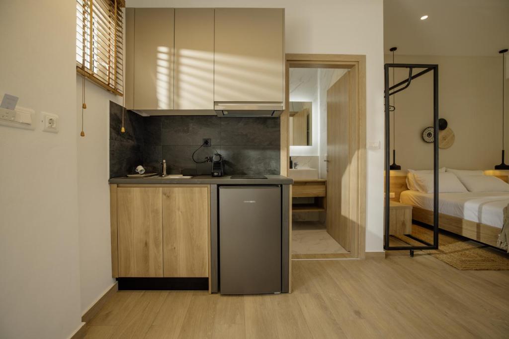 a kitchen with a sink and a bed in a room at Casa Costa Suites in Kanali