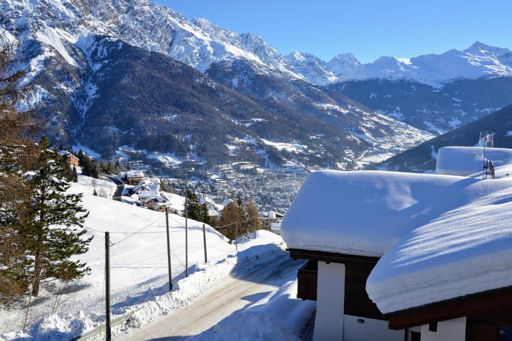 Casa cubierta de nieve con vistas a la montaña en Chalet Apartment Gran Zebrù en Oga