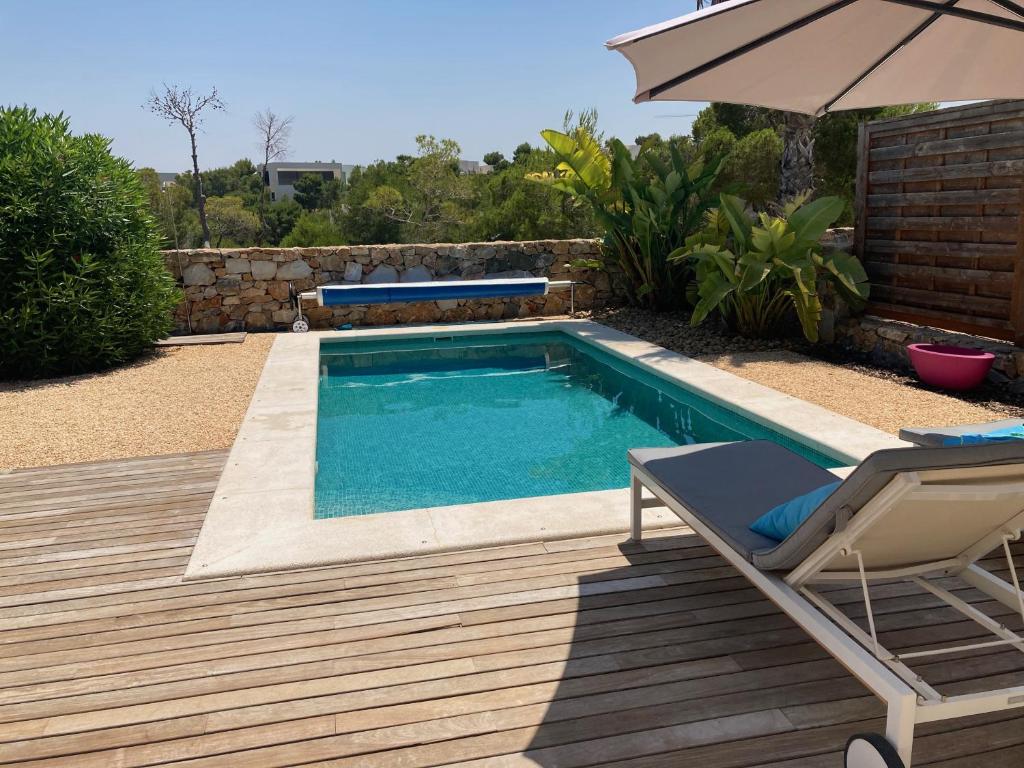 - une piscine avec une chaise et un parasol dans l'établissement Villa Paolina in urb Las Colinas, à Orihuela Costa