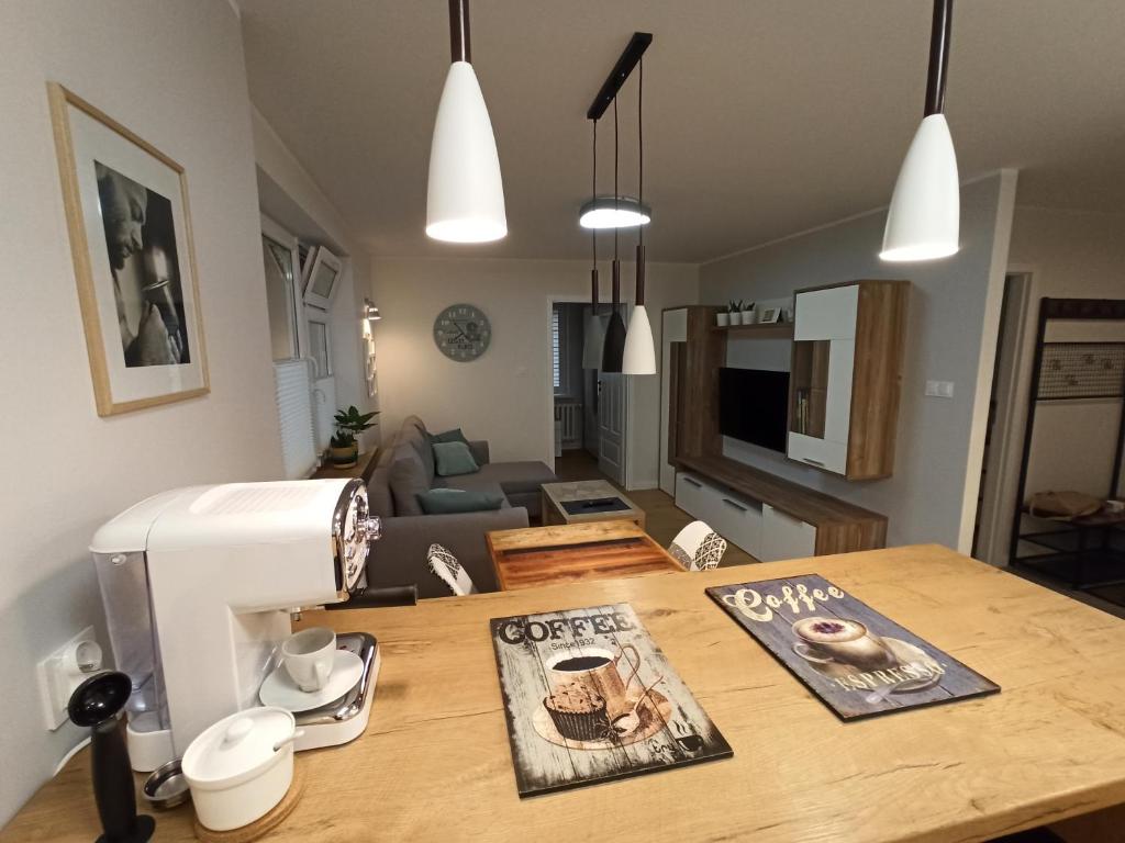eine Küche und ein Wohnzimmer mit einem Tisch und einer Nähmaschine in der Unterkunft Flat White Centrum in Suwałki