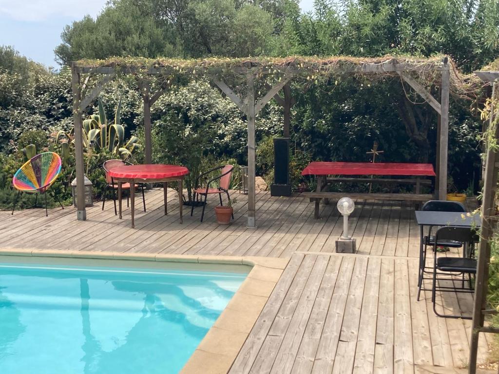 a patio with a table and a picnic table next to a pool at B&B Macchia Verdata avec piscine in Monacia-dʼAullène