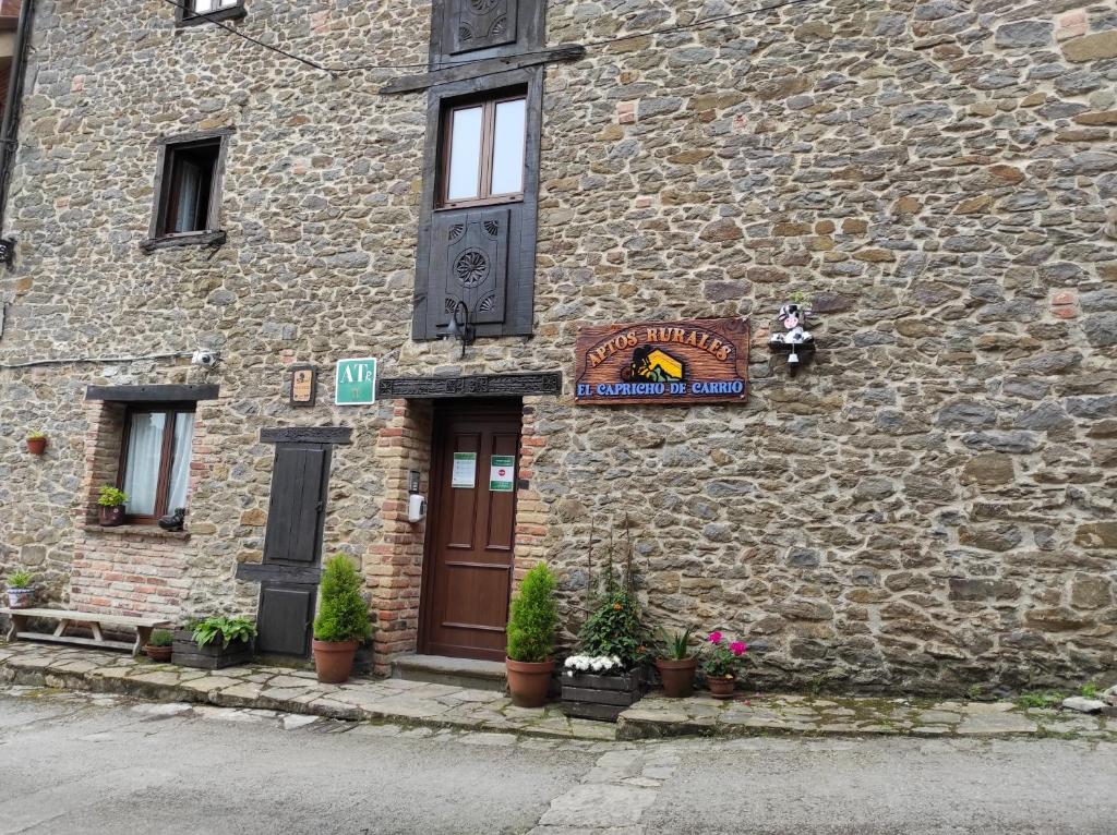 a building with a sign on the side of it at Apartamentos rurales el capricho de carrio in Pola de Laviana