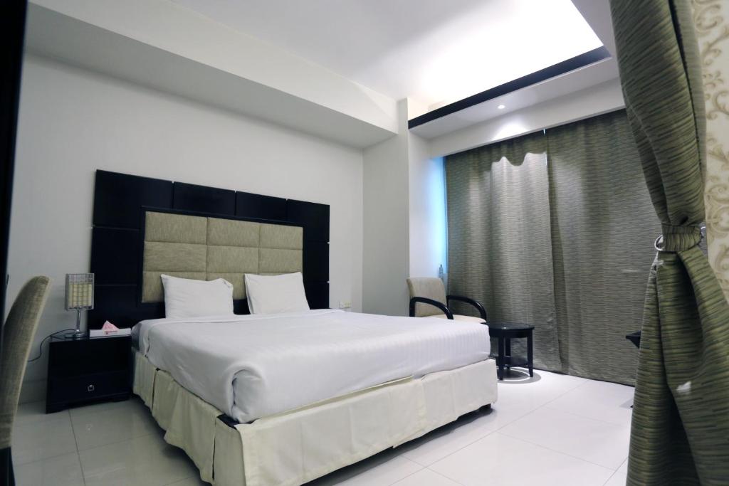 A bed or beds in a room at Orchid Business Hotel