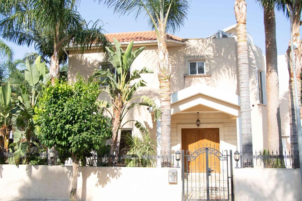 une maison avec des palmiers devant elle dans l'établissement VillaHoliday, à Oroklini