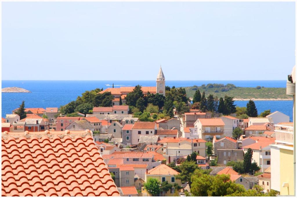 Blick auf eine Stadt mit Orangendächern und das Meer in der Unterkunft Marit in Primošten