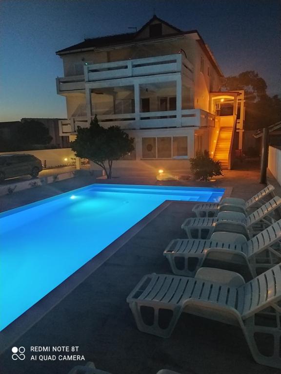 uma villa com piscina à noite em Apartments Mirko&Ana em Bibinje