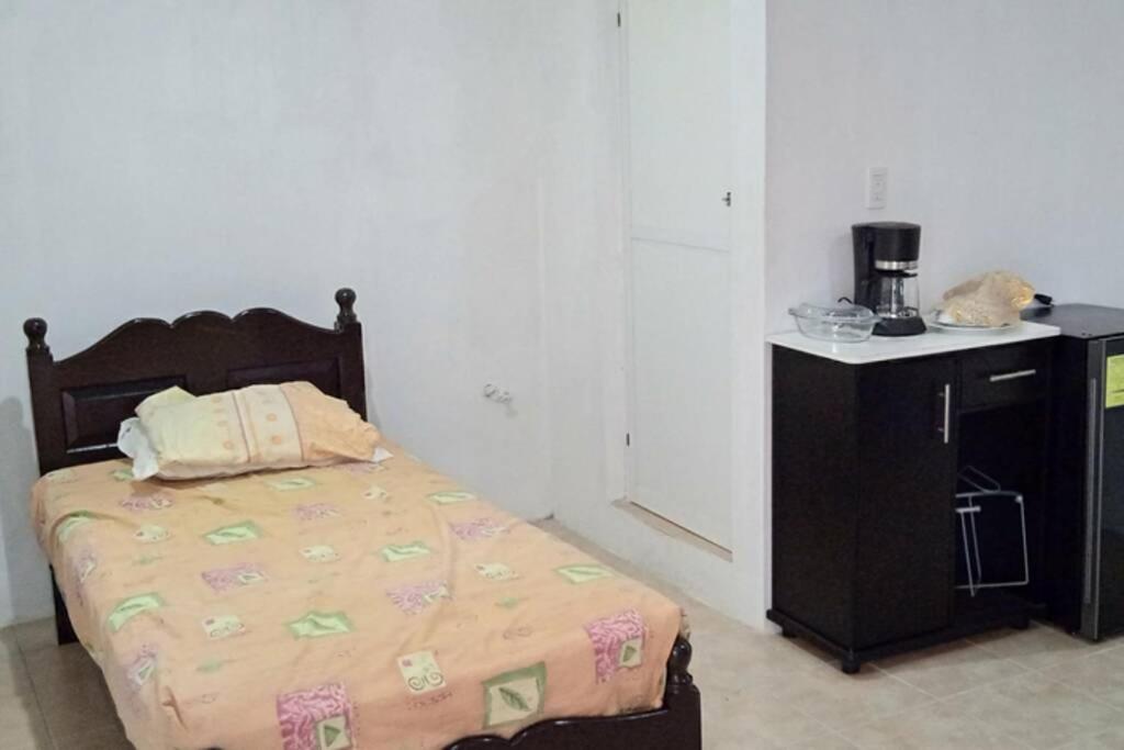 a bedroom with a bed and a table with a coffee maker at CITY AND SEA VIEW JARDINES in Campeche