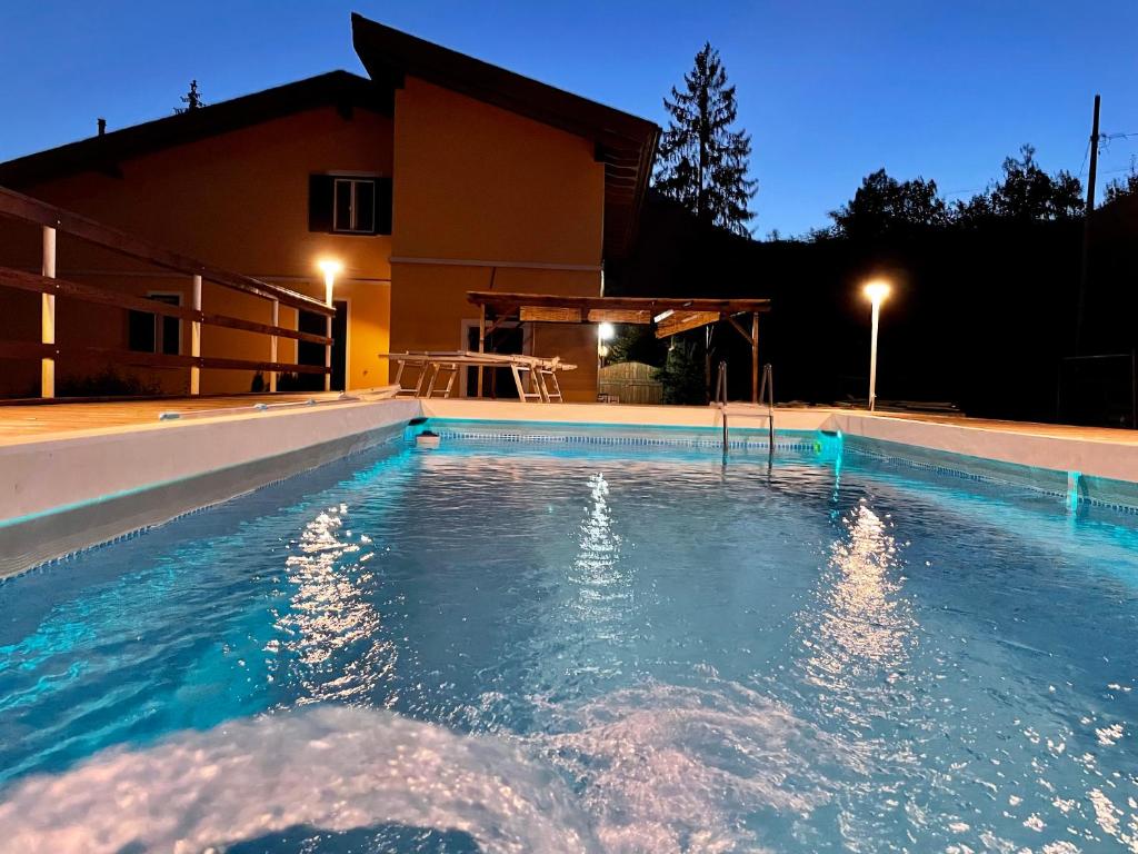 a swimming pool in front of a house at night at Impronte Nel Bosco in Calice al Cornoviglio