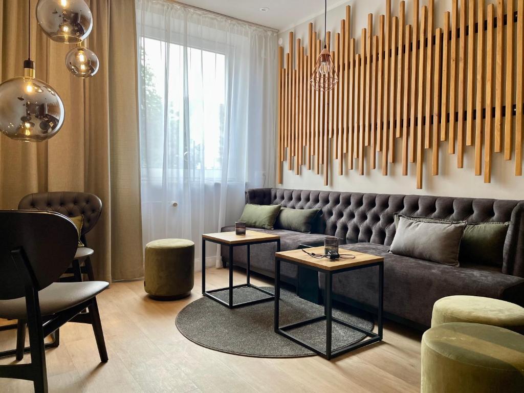 een woonkamer met een bank en 2 tafels bij Hotel Schultheiss Hameln in Hameln