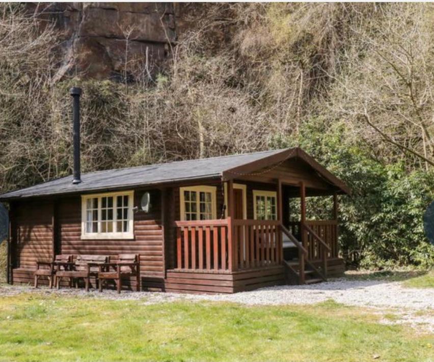 uma cabana com uma mesa de piquenique em frente em 3bears Log Cabin Whatstandwell Matlock Derbyshire em Crich