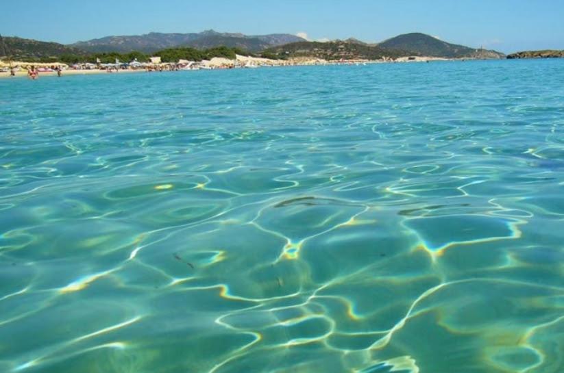 una grande pozza d'acqua con una spiaggia sullo sfondo di Sole e relax a Pula