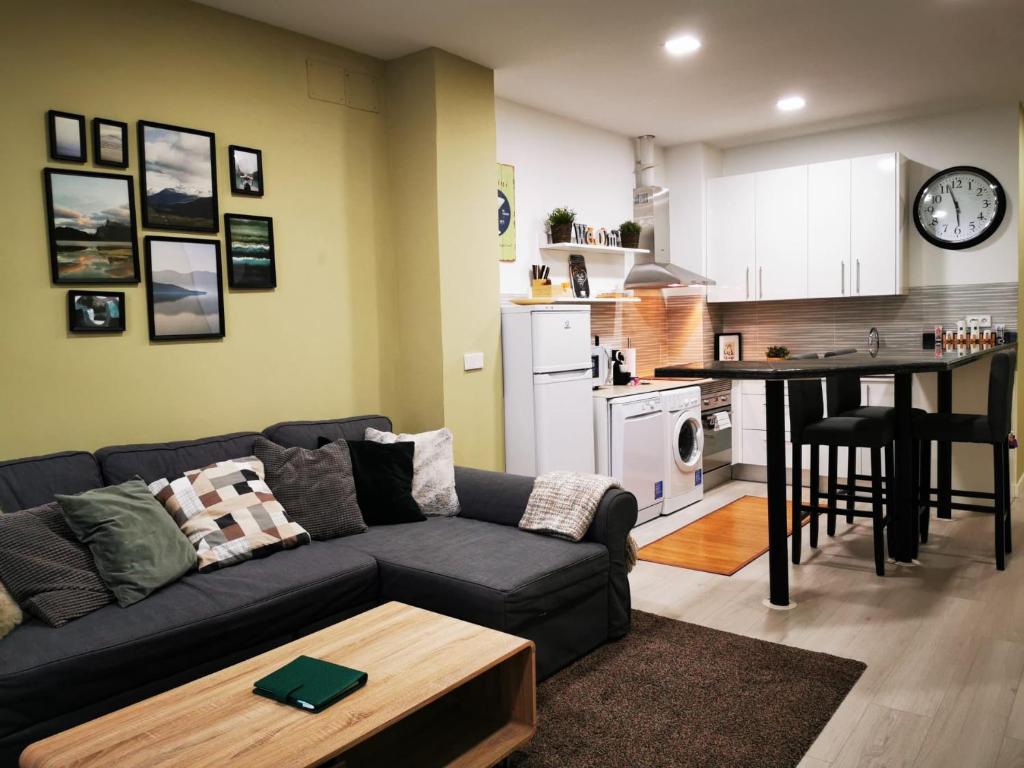 a living room with a couch and a kitchen at Your comfy stay in the Center of Madrid in Madrid