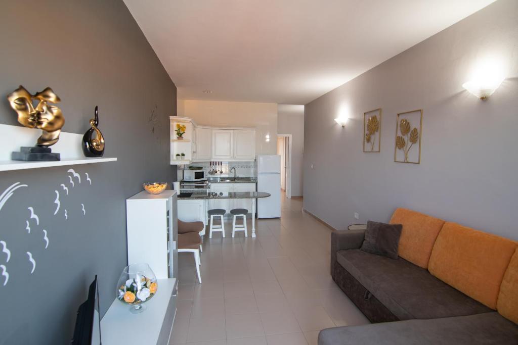 雷斯廷加的住宿－VV Norte y Sur，客厅以及带沙发和桌子的厨房。