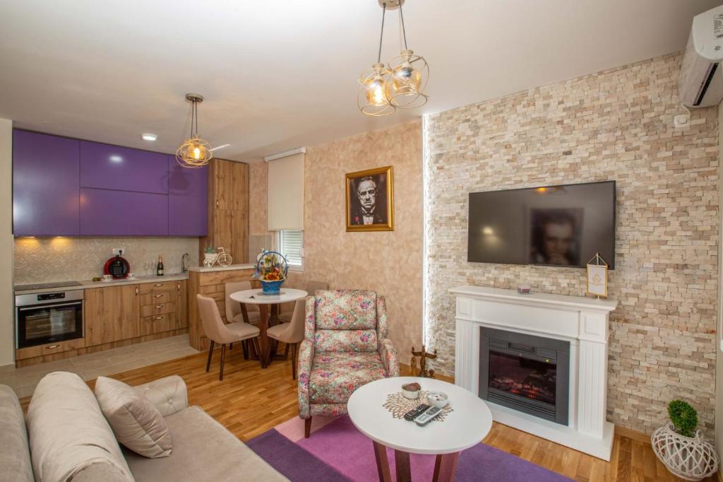 Impressive Premium Apartment في نيكشيتش: غرفة معيشة مع أريكة ومدفأة