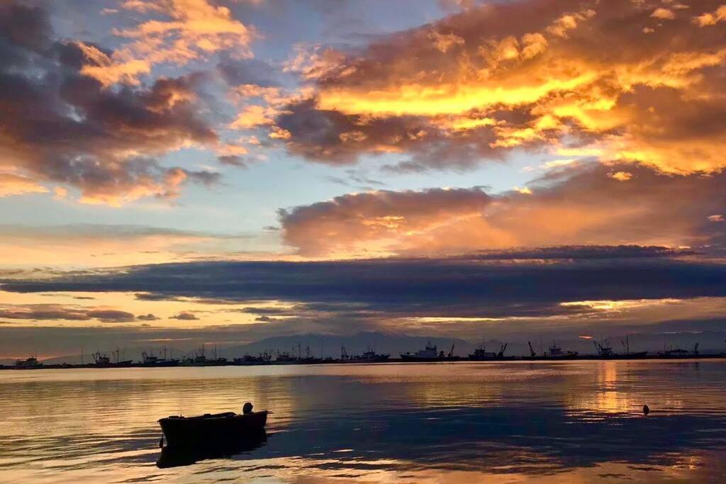 un bateau assis dans l'eau au coucher du soleil dans l'établissement VYRON 1 ELEGANCE, à Néa Michanióna