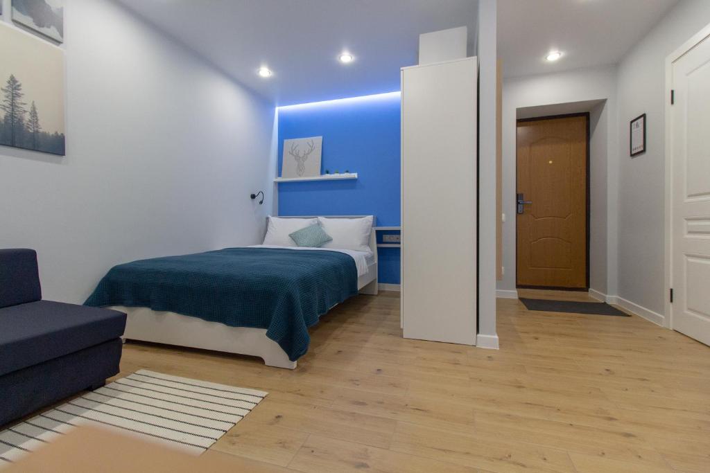 a bedroom with a bed and a blue wall at Luxury studio на Пушкина in Alekseyevka
