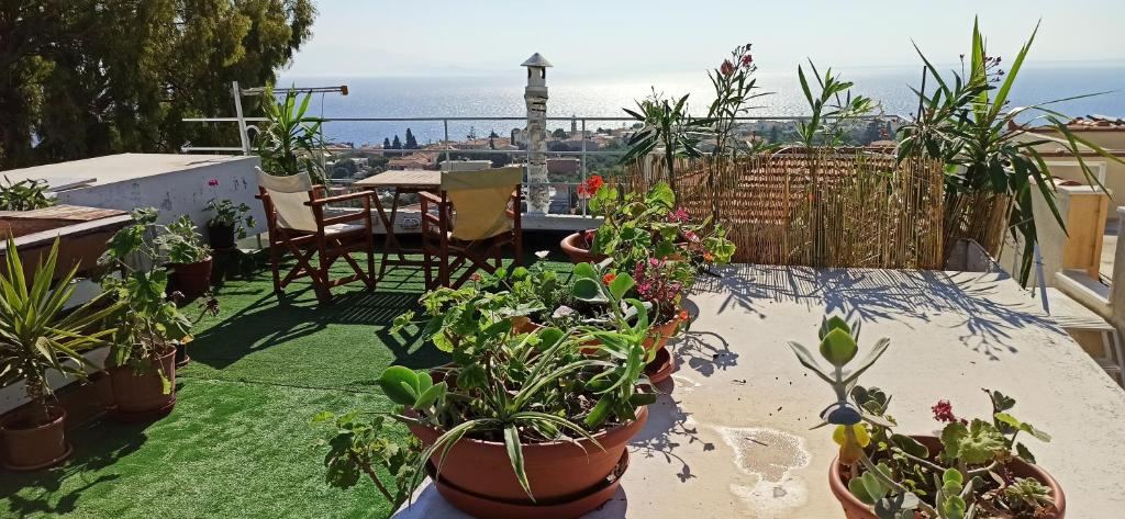 a patio with potted plants and a table with a view at Maris full apartment with roof garden access in Chios
