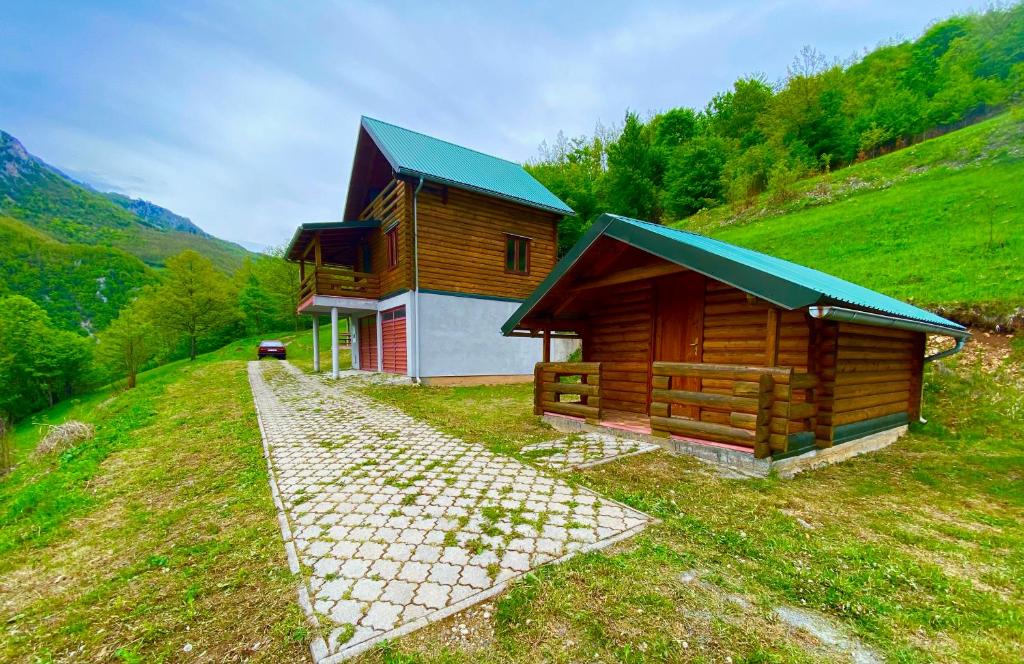 een houten hut met een groen dak op een heuvel bij Kamp Kaludra in Mojkovac
