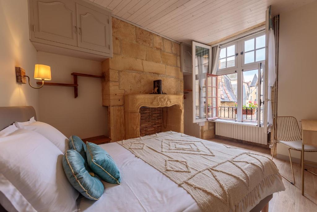 a bedroom with a large bed and a fireplace at Le Lys Dort Sarlat in Sarlat-la-Canéda