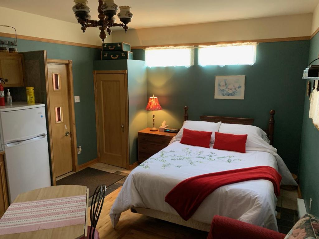 um quarto com uma cama com almofadas vermelhas em Chez Odette, loft intime em Roberval