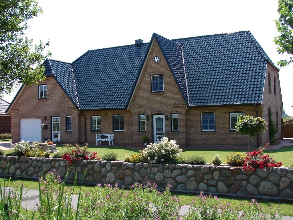 ein Backsteinhaus mit schwarzem Dach in der Unterkunft Ferienwohnung Scheel in Nordstrand