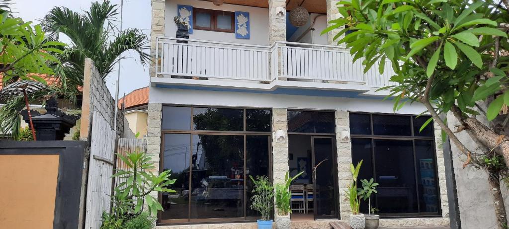 a house with large glass windows and a balcony at Turtle Island Homestay in Sanur