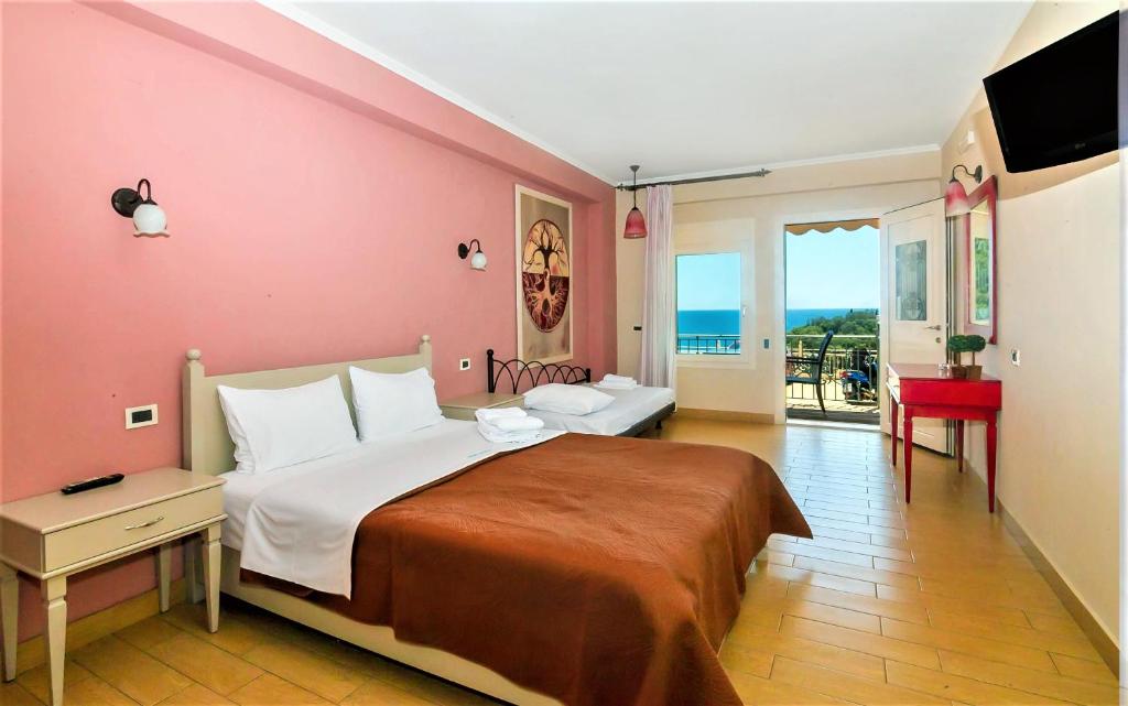 a bedroom with a large bed with a pink wall at Villa Letista in Parga