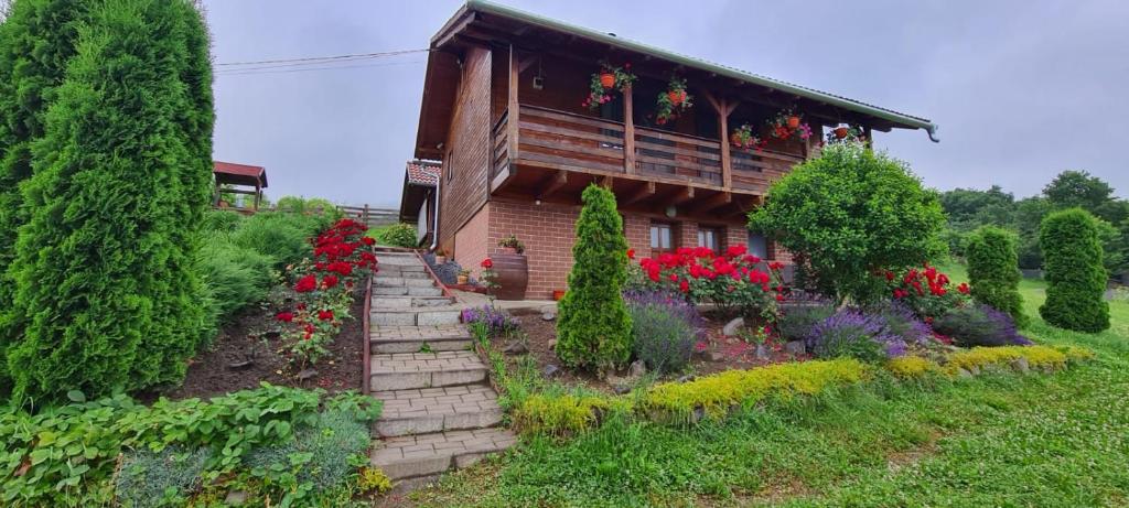 ein Haus mit einem Blumengarten davor in der Unterkunft Casa Szabó Ház in Sovata