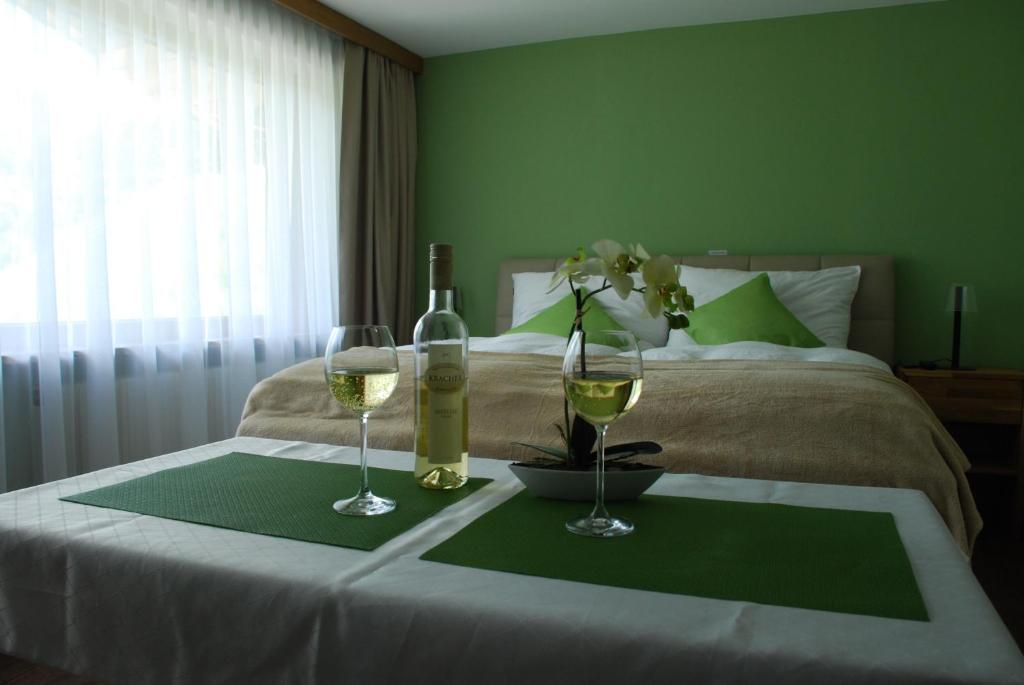 a bedroom with a bed with two glasses of wine at Alpenhaus Donnerkogel in Annaberg im Lammertal