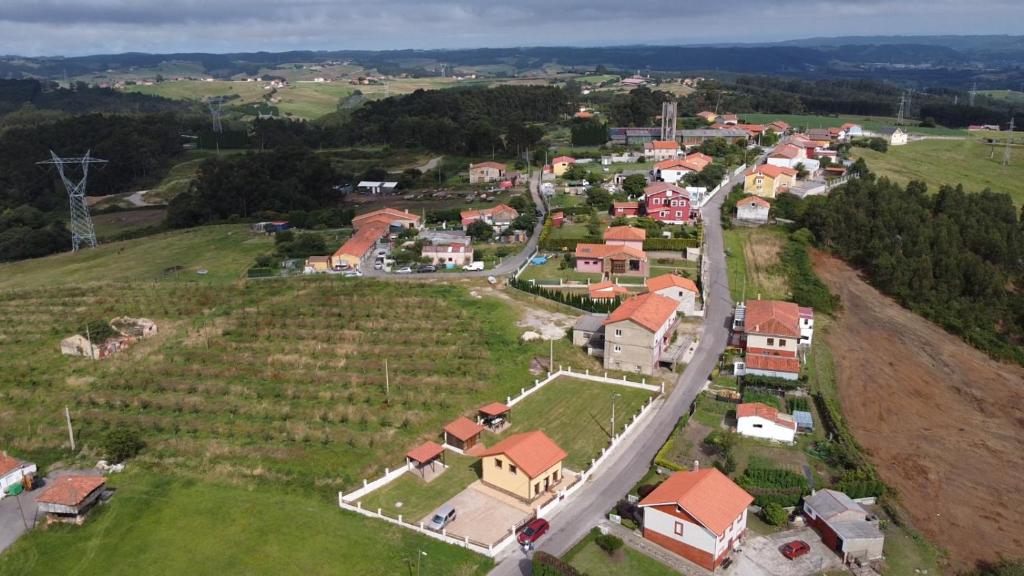 una vista aérea de una pequeña localidad con carretera en Les Casines, en Luanco