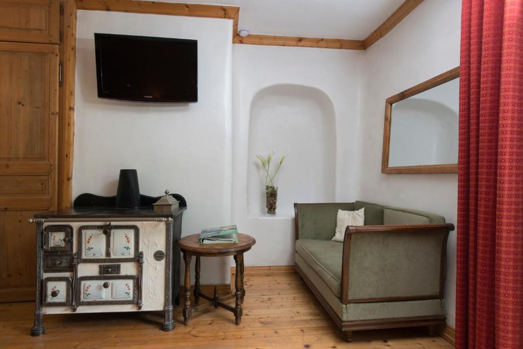 a living room with a couch and a tv at Au Cheval Blanc - appartements et chambres d'hôtes in Albertville