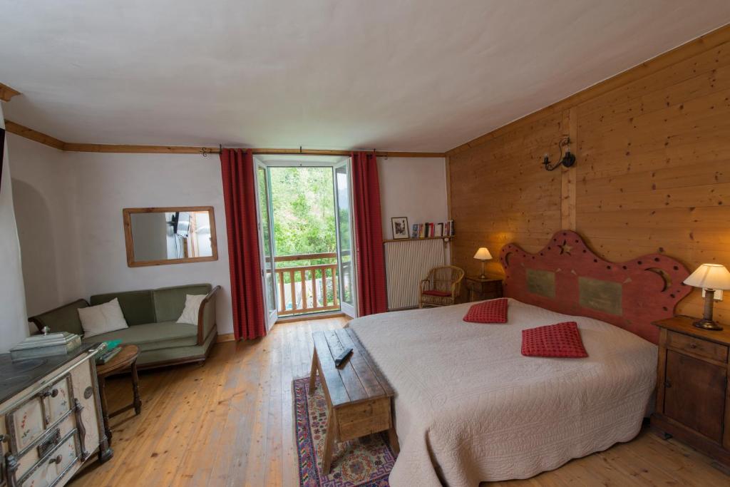 Au Cheval Blanc - appartements et chambres d'hôtes في ألبرتفيل: غرفة نوم بسرير واريكة في غرفة