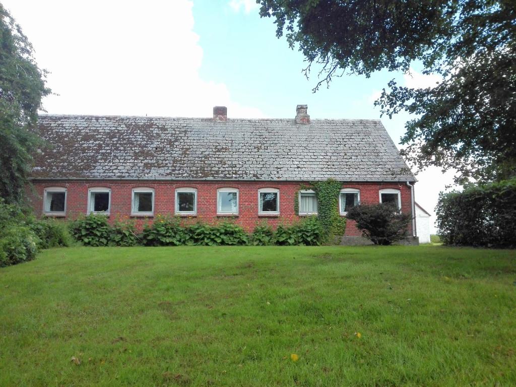 une maison en briques rouges avec une grande cour dans l'établissement Holtens Gaard, à Hobro