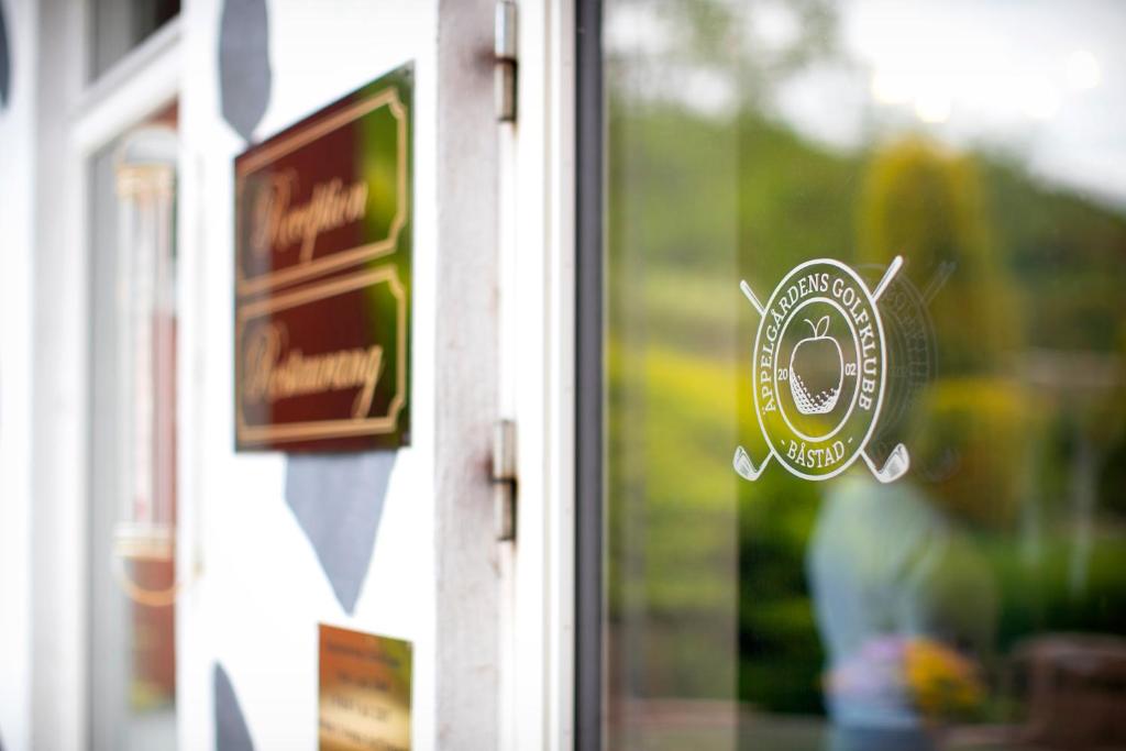 una pegatina en una ventana de cristal de una tienda en Äppelgårdens Golfklubb, en Båstad