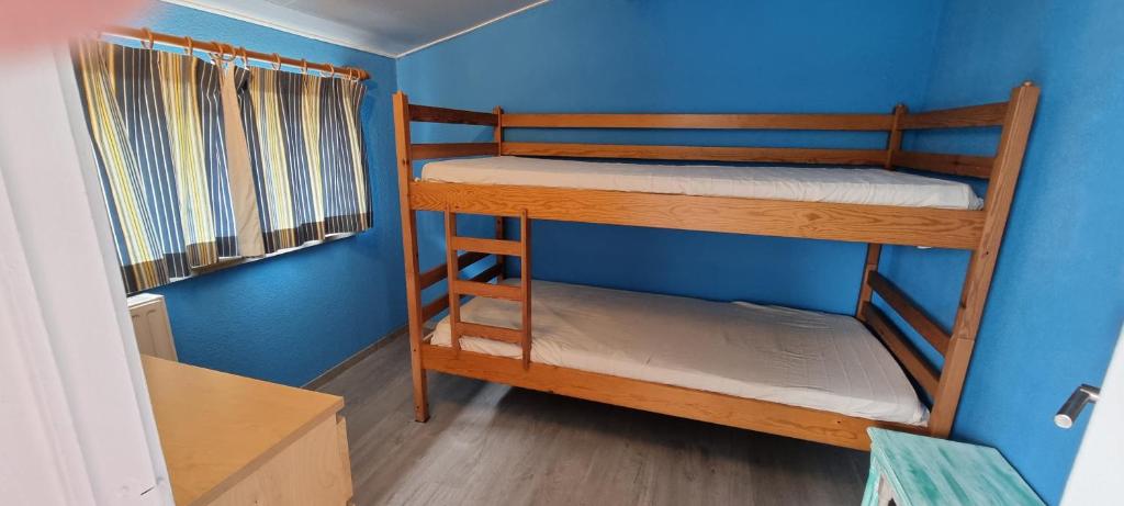 2 Etagenbetten in einem Zimmer mit blauer Wand in der Unterkunft Surfin in Koksijde