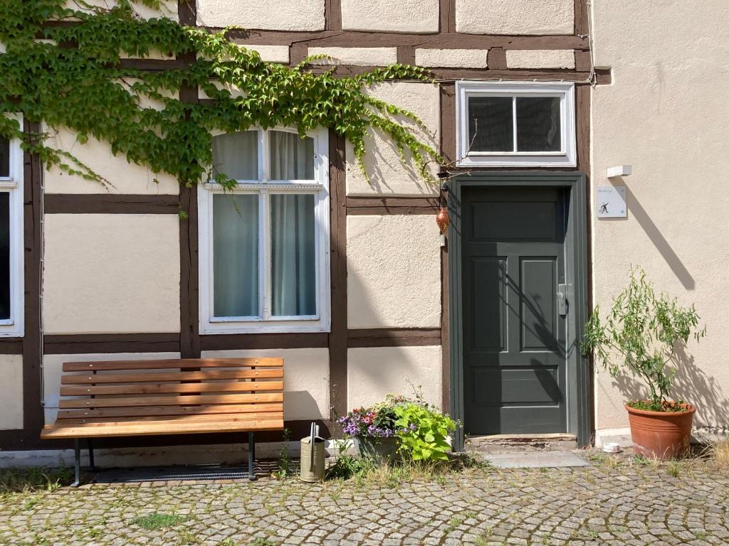 a wooden bench in front of a building with a door at HERBERGE 28 Ferienwohnung für bis zu 6 Personen in Saalfeld