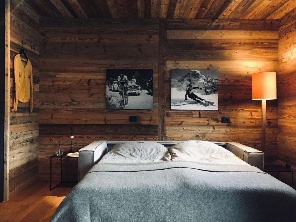 um quarto com uma cama numa parede de madeira em Dolomiti Dreams em Selva di Val Gardena