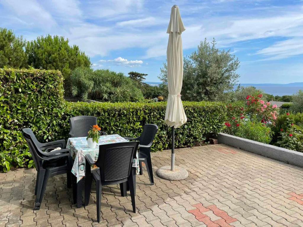 a table and chairs with an umbrella on a patio at Ana in Kostrena