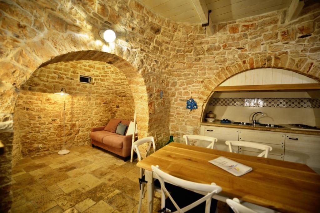 a room with a stone wall and a wooden table at Trulli e Puglia Resort in Alberobello
