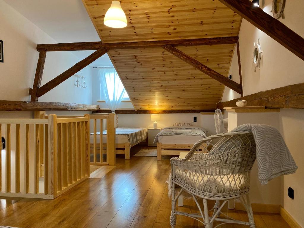 a living room with a bed and a chair at Agroturystyka Widokówka Nielisz in Nielisz