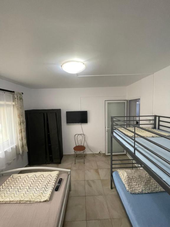 een kamer met 3 stapelbedden en een flatscreen-tv bij Apartament Sofia in Costinesti