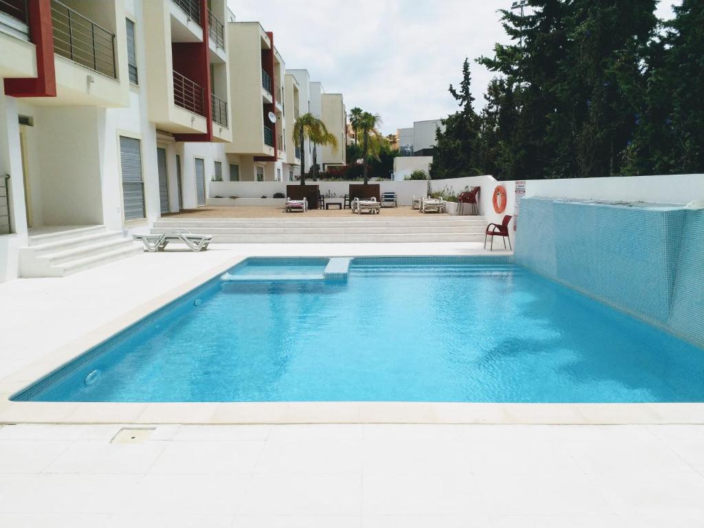 a swimming pool in front of a building at Apartamento T2 Eucalipto 2A in Olhos de Água